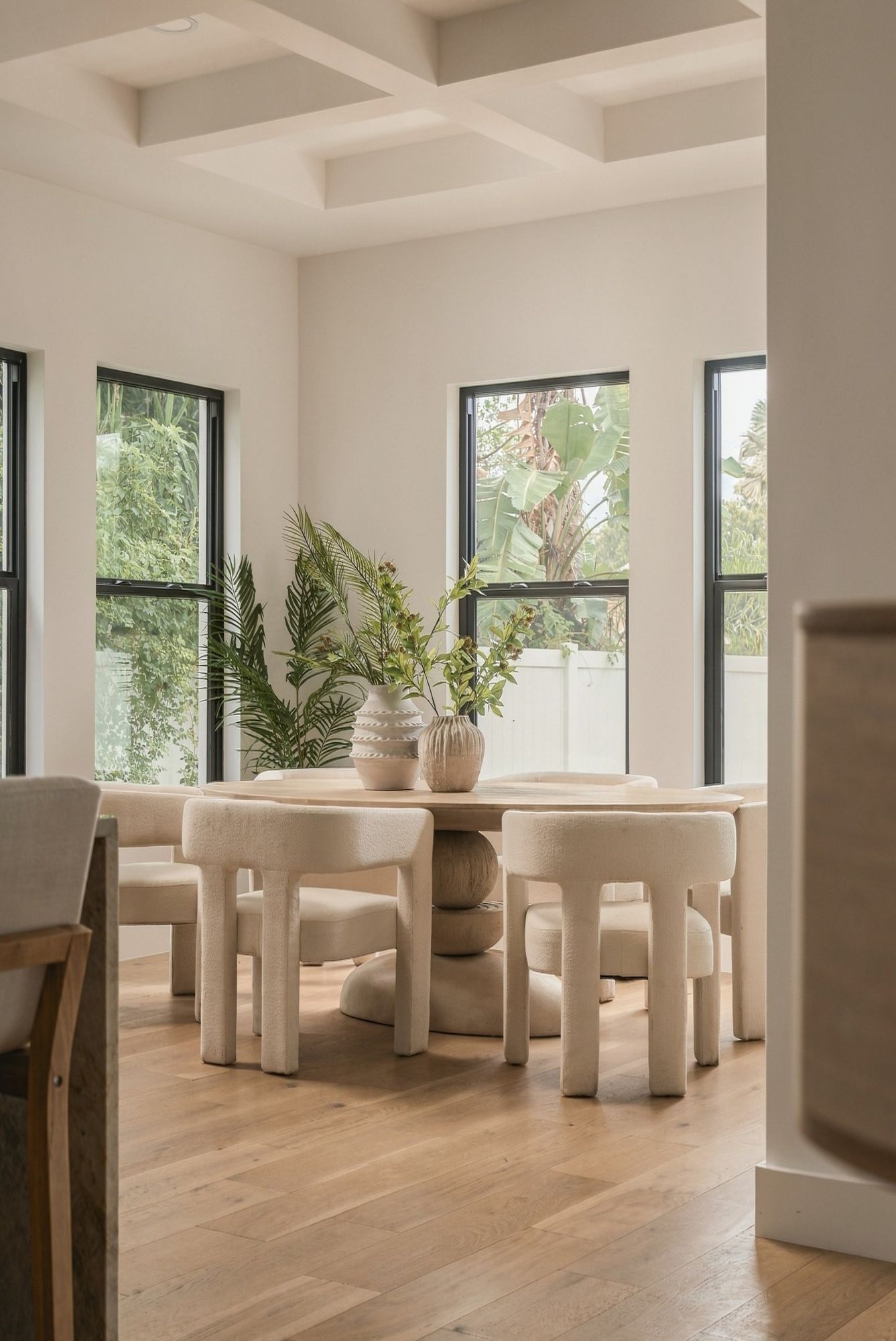 Dining area with sculptural boucle chairs and a round pedestal table