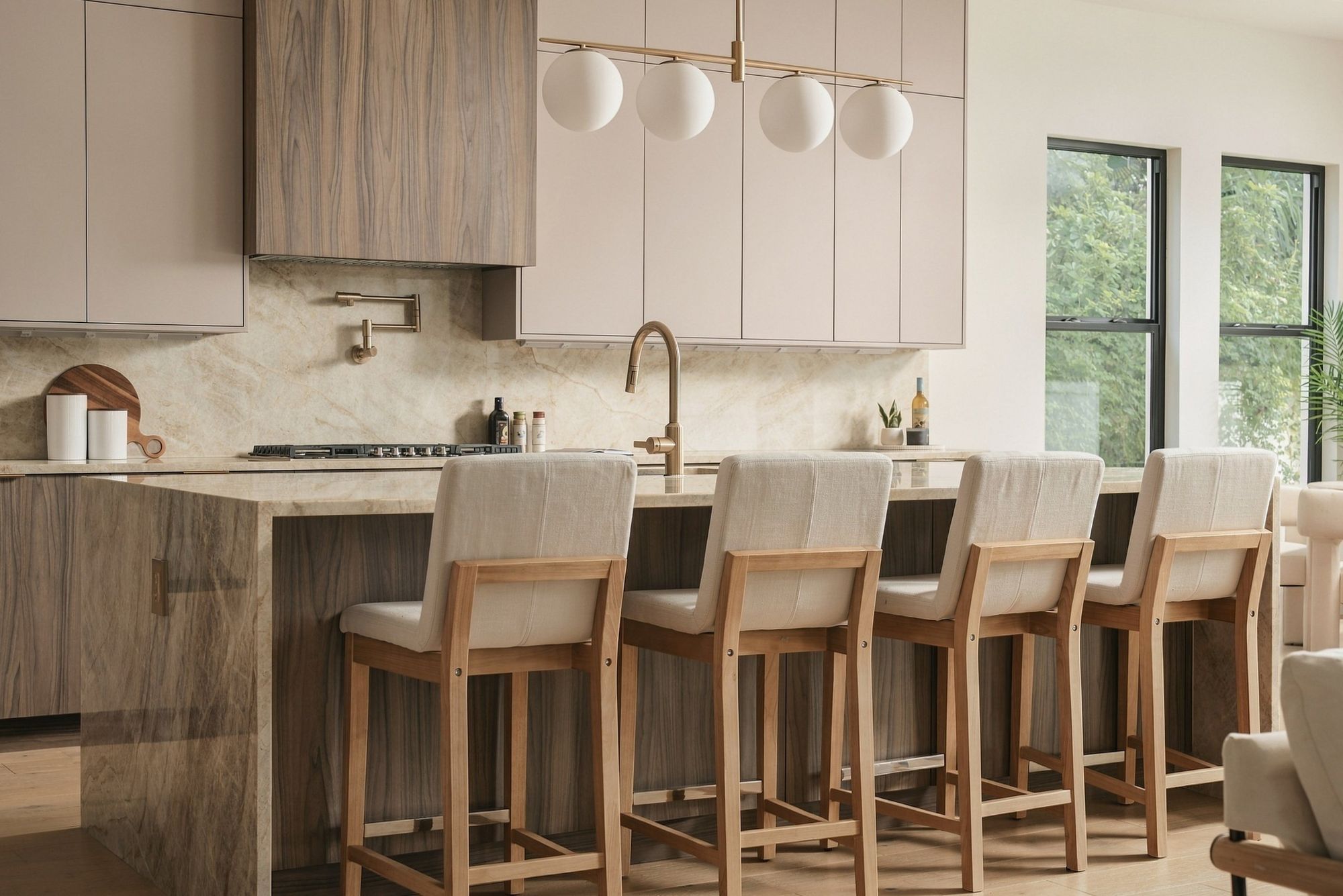 Kitchen island with counter stools beneath globe pendant lights